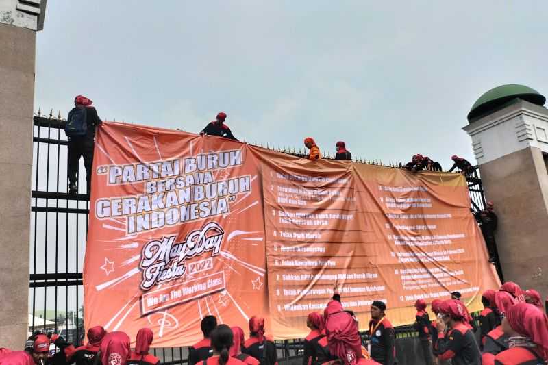 Aksi May Day, Pagar Gedung Parlemen Diselimuti Spanduk Oranye Berisi 13 Tuntutan Buruh